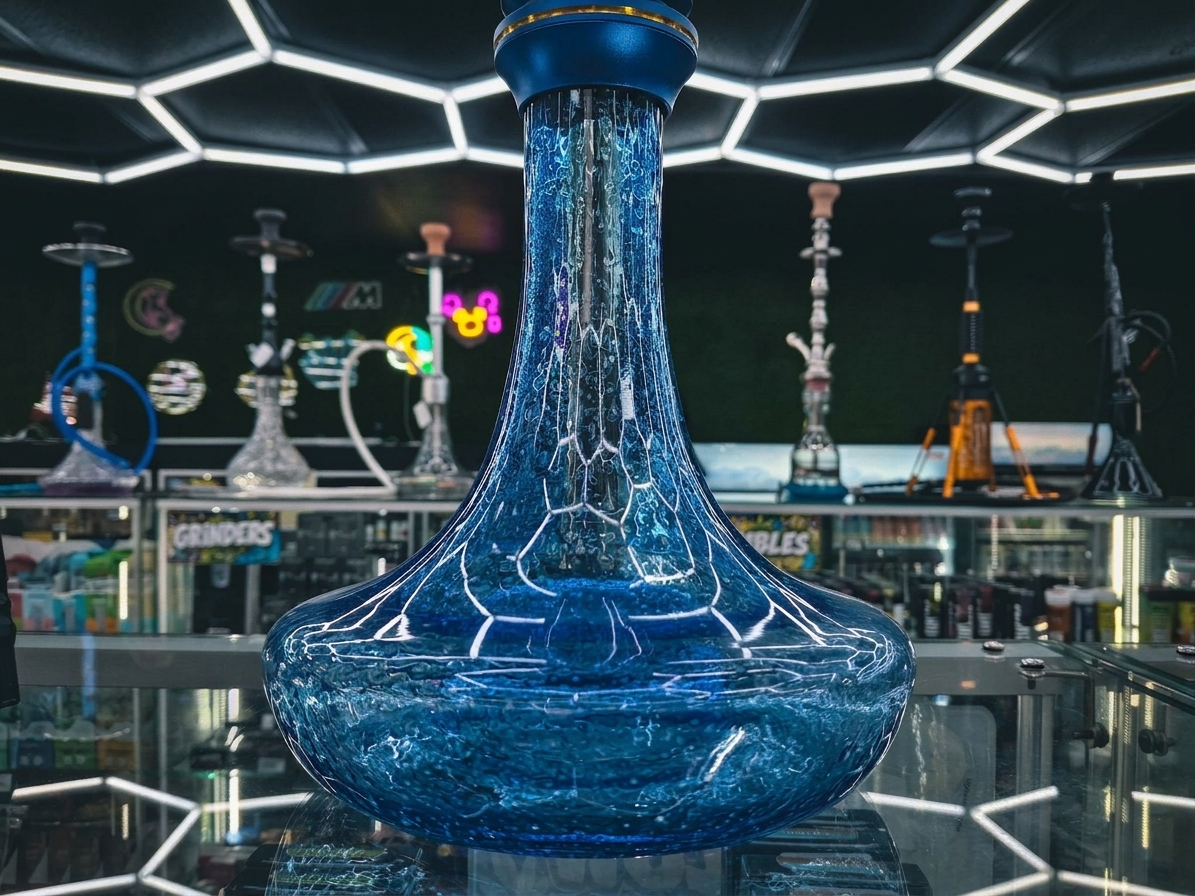 A hexagonal ice-white LED ceiling grid glowing over a blue crackle-glass hookah base on display at Cloud Smoke Shop.