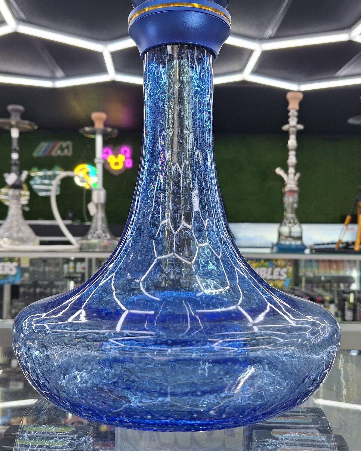 A hexagonal ice-white LED ceiling grid glowing over a blue crackle-glass hookah base.