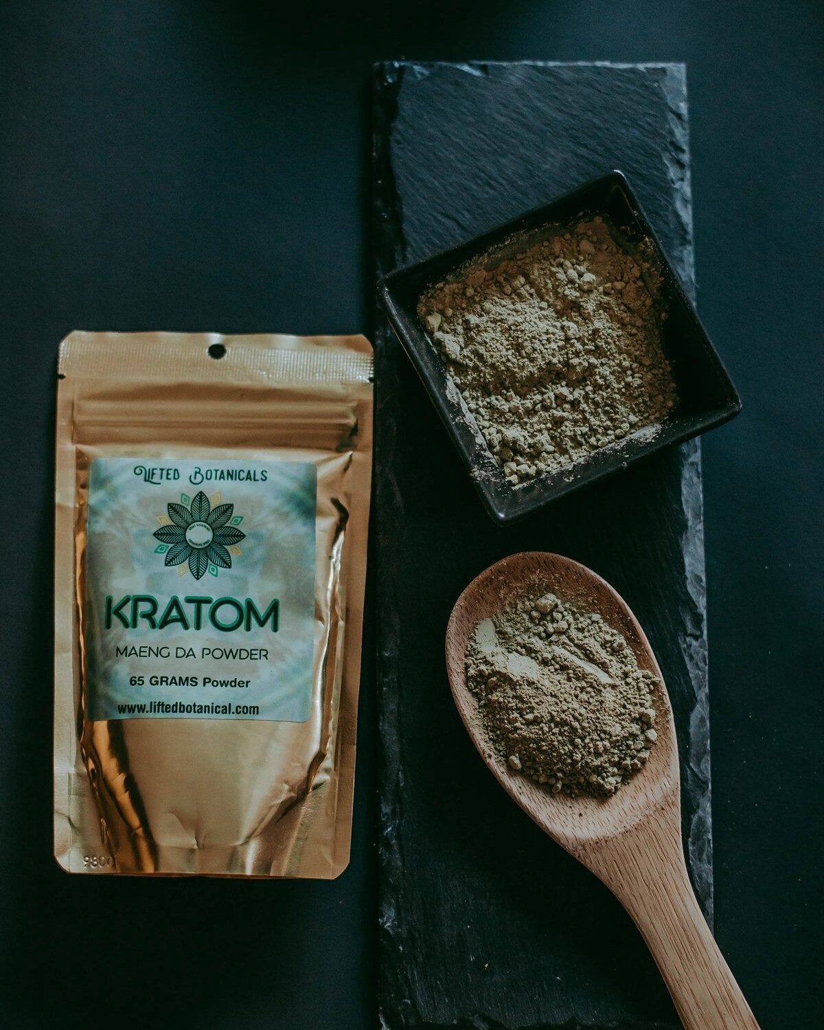 A gold Lifted Botanicals kratom powder pouch beside bowls of ground kratom powder.